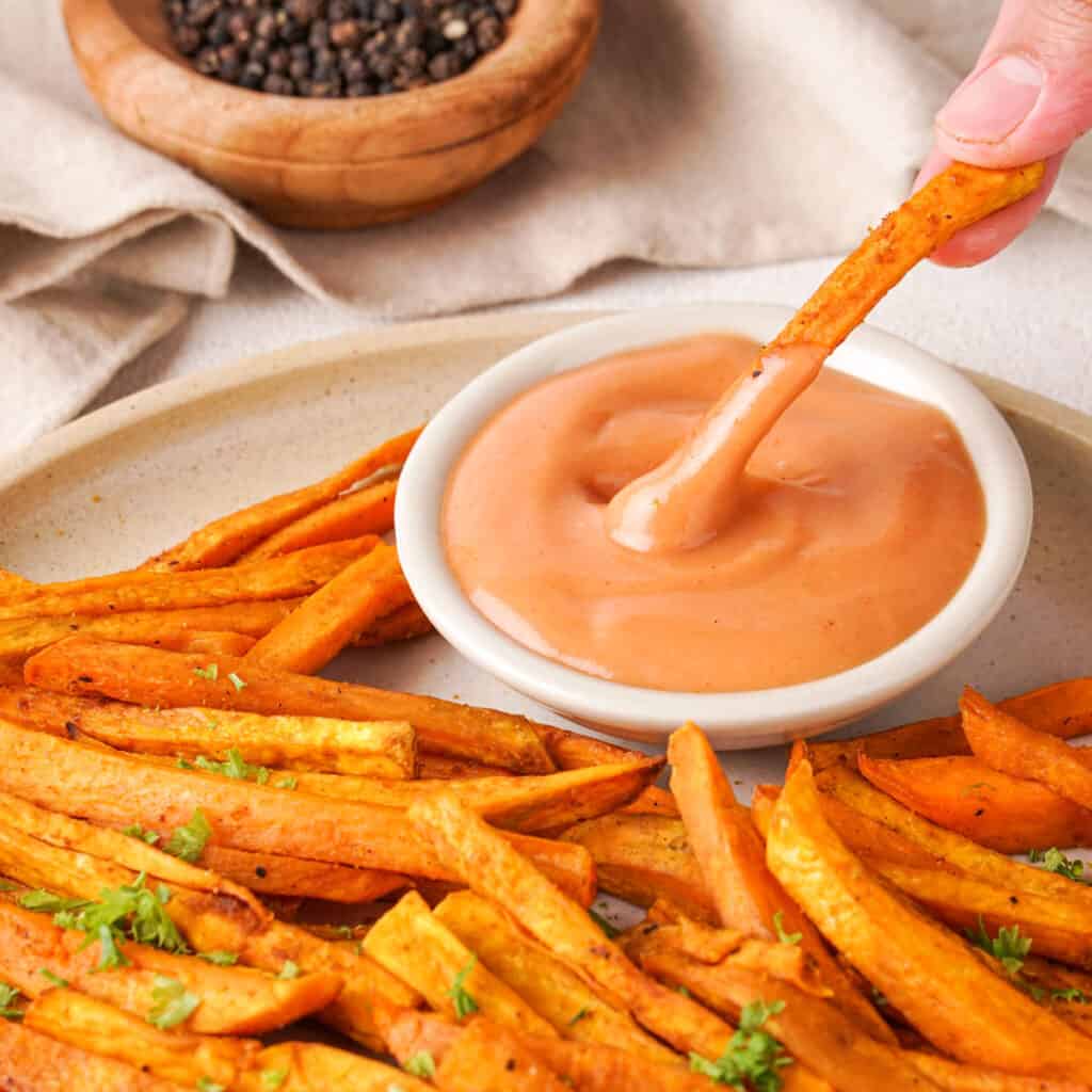 dipping sweet potato fry into dipping sauce