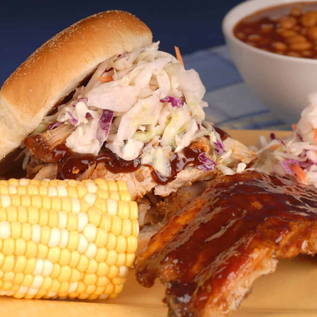 plate of bbq with corn, coleslaw, ribs, and sandwich