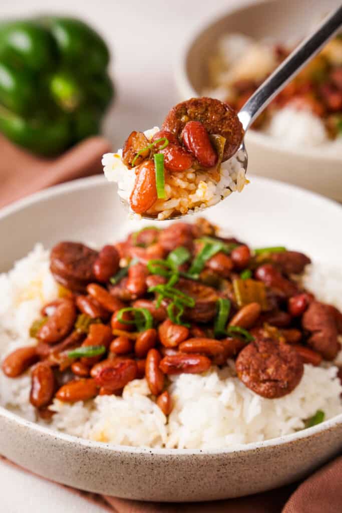 spoonful of red beans and rice held over plate of red beans and rice