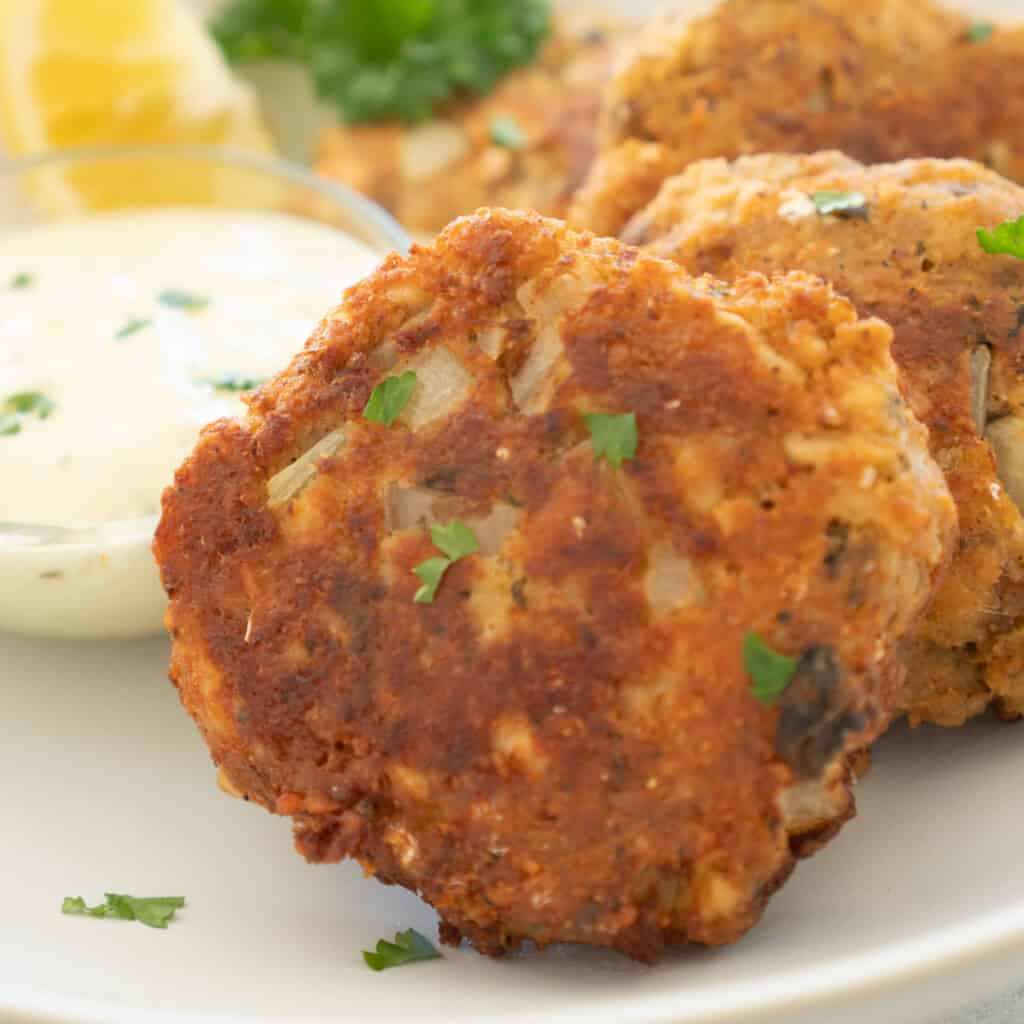 close up of salmon patties on white plate
