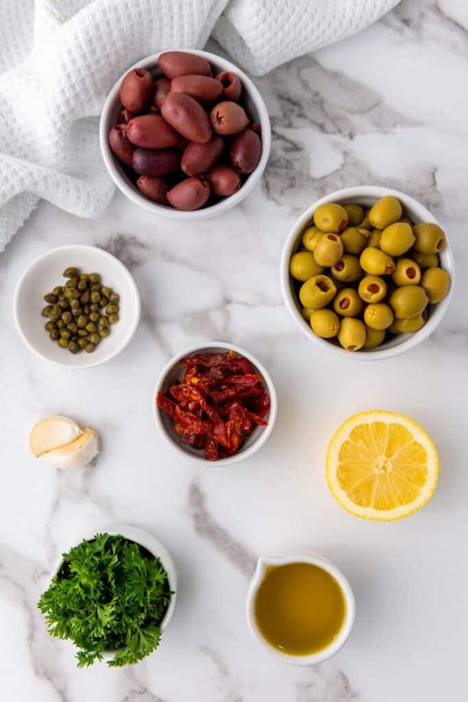 olive tapenade ingredients in bowls on counter