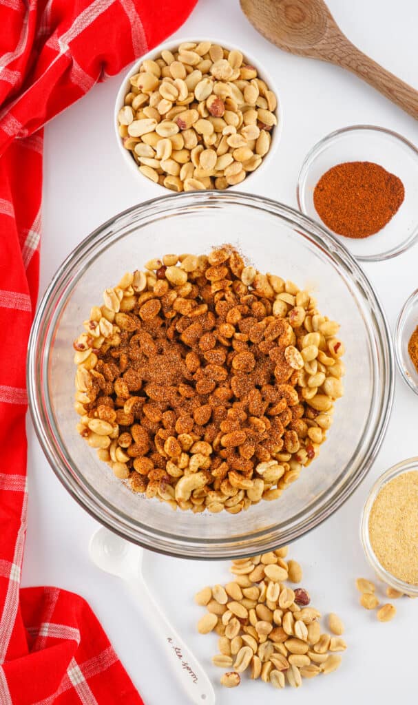 mixing spicy peanuts in glass bowl