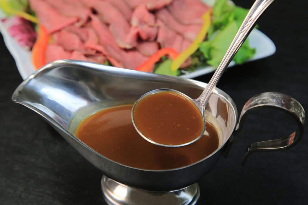 ladling au jus from a silver gravy boat
