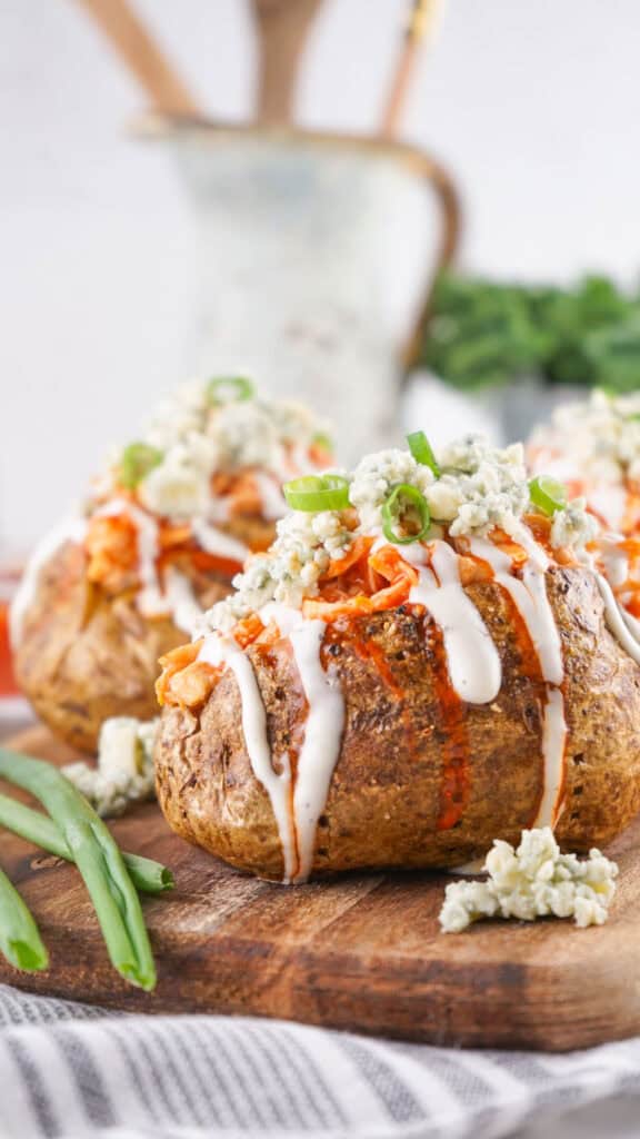 buffalo chicken baked potatoes on cutting board