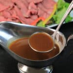 ladling au jus from a silver gravy boat