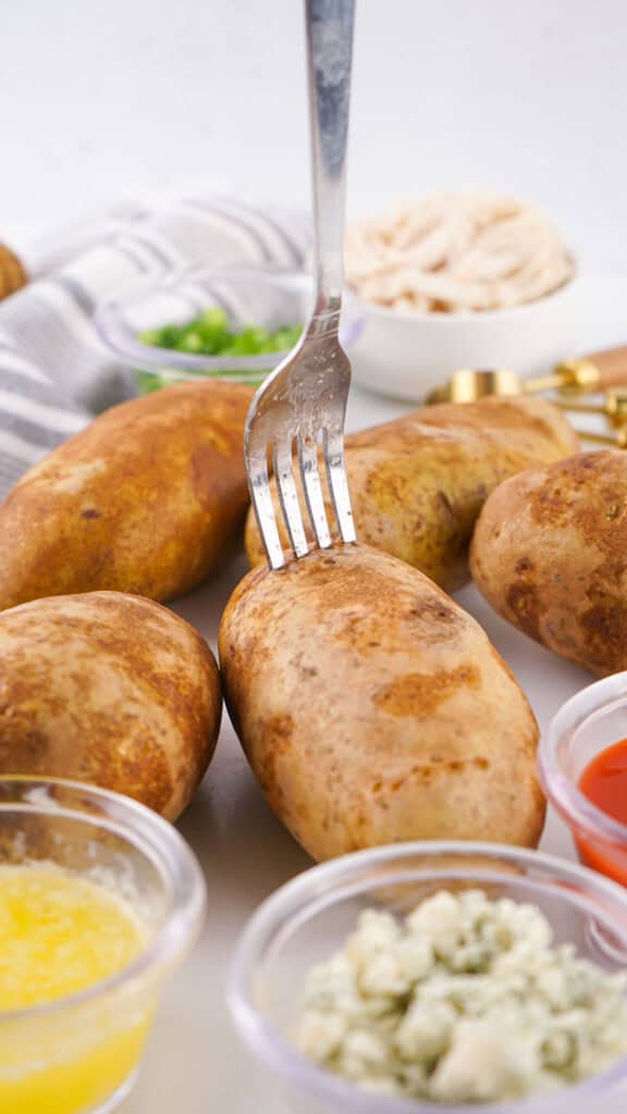 piercing russet potato with fork