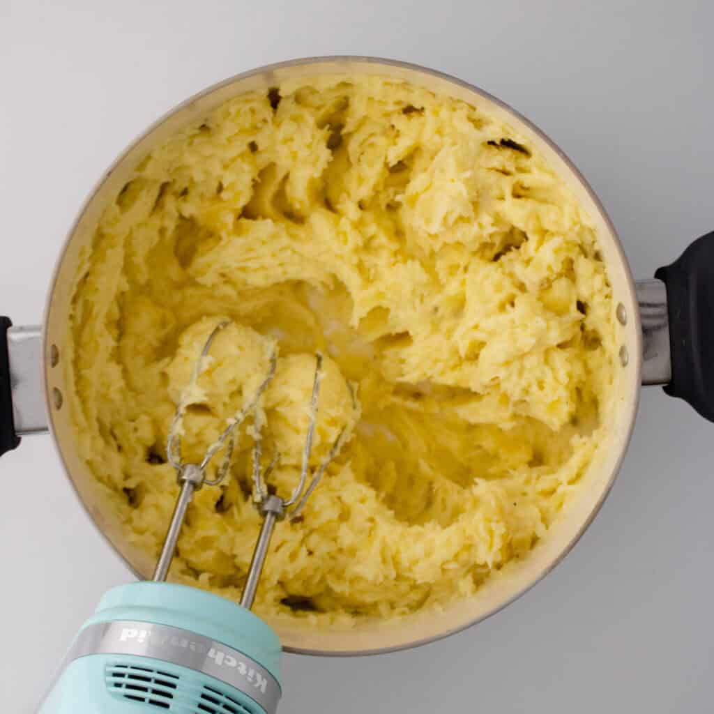 mixer whipping potatoes in pot