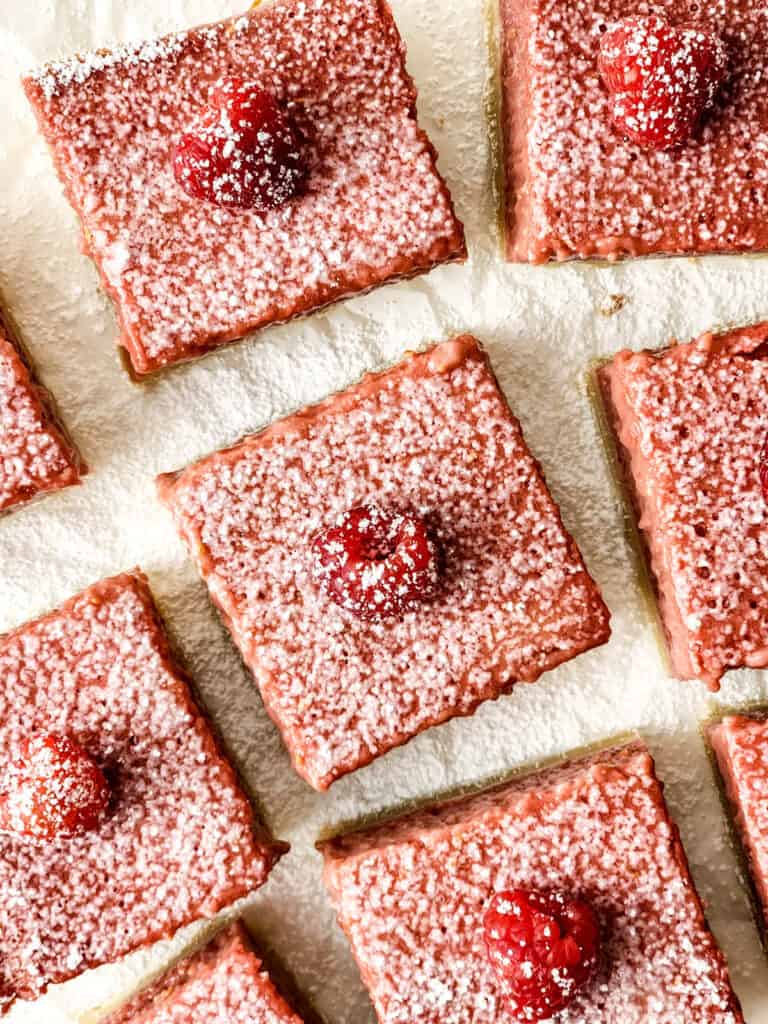 raspberry lemon bars on parchment paper