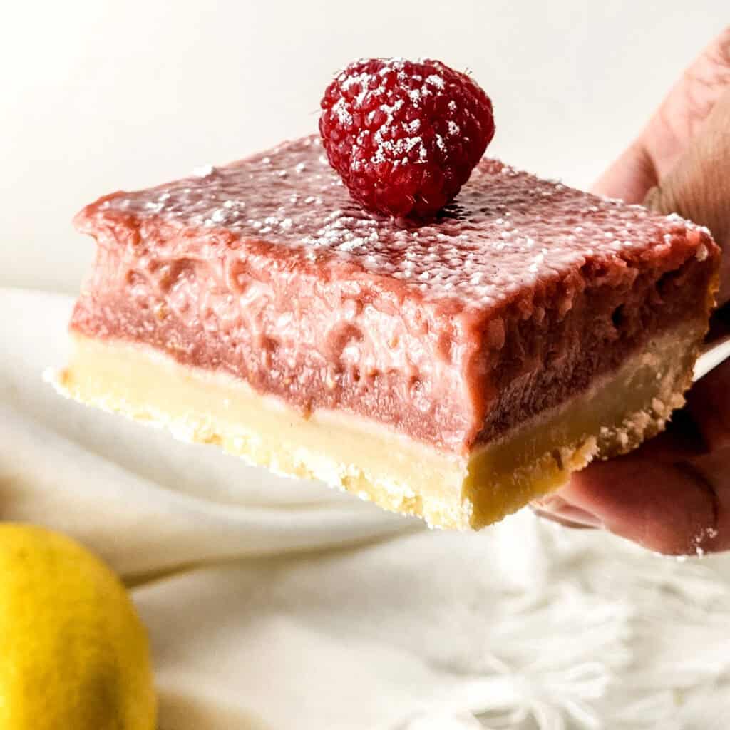 hand holding raspberry lemon bar