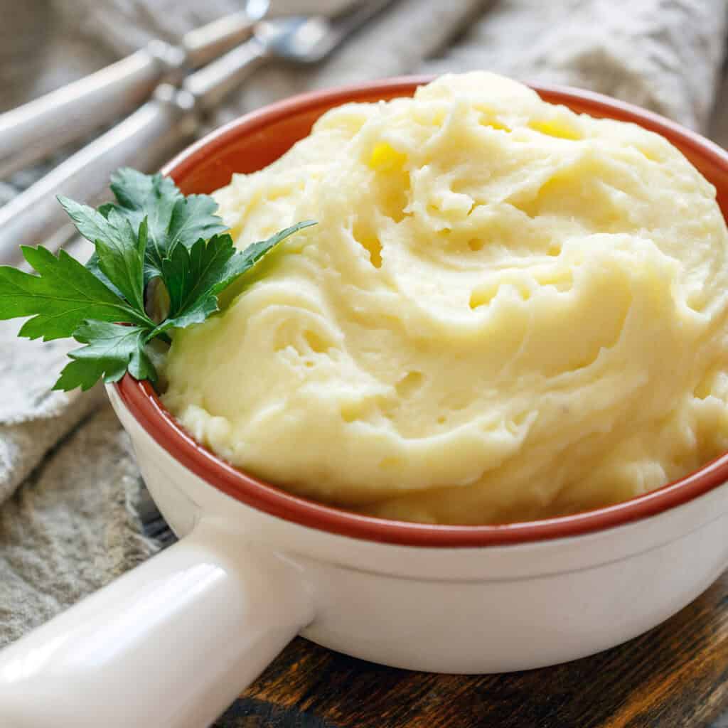 whipped mashed potatoes in white serving dish with handle