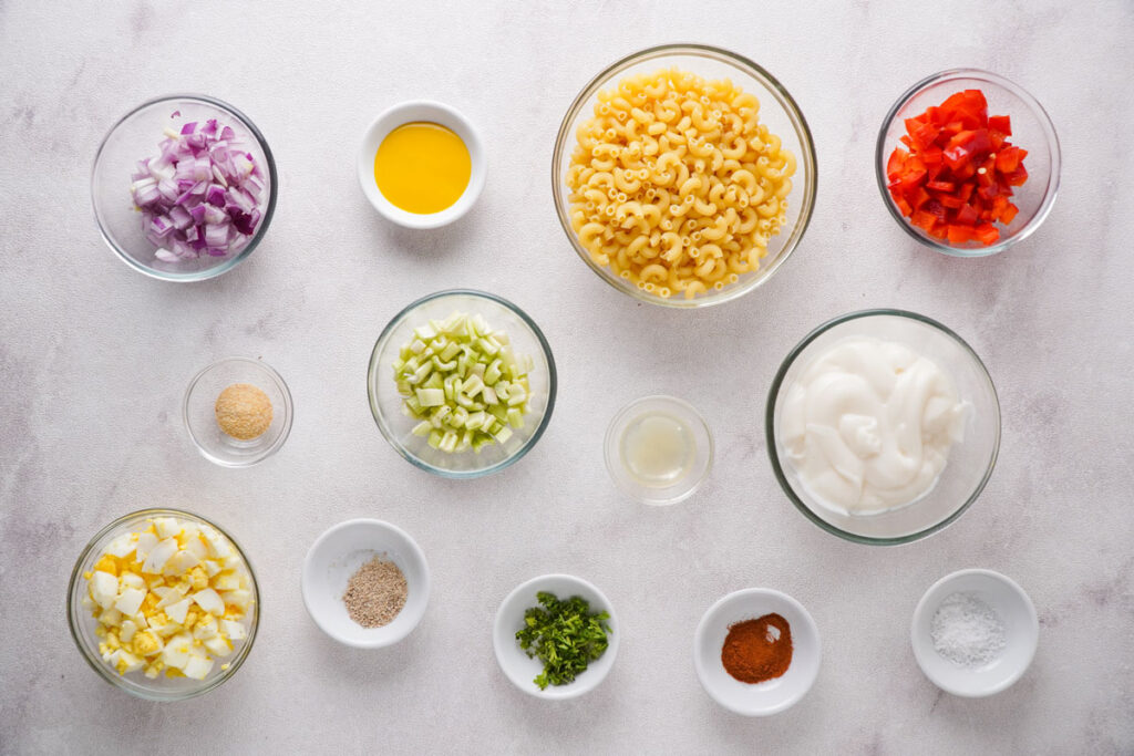 southern macaroni salad ingredient in glass bowls on countertop