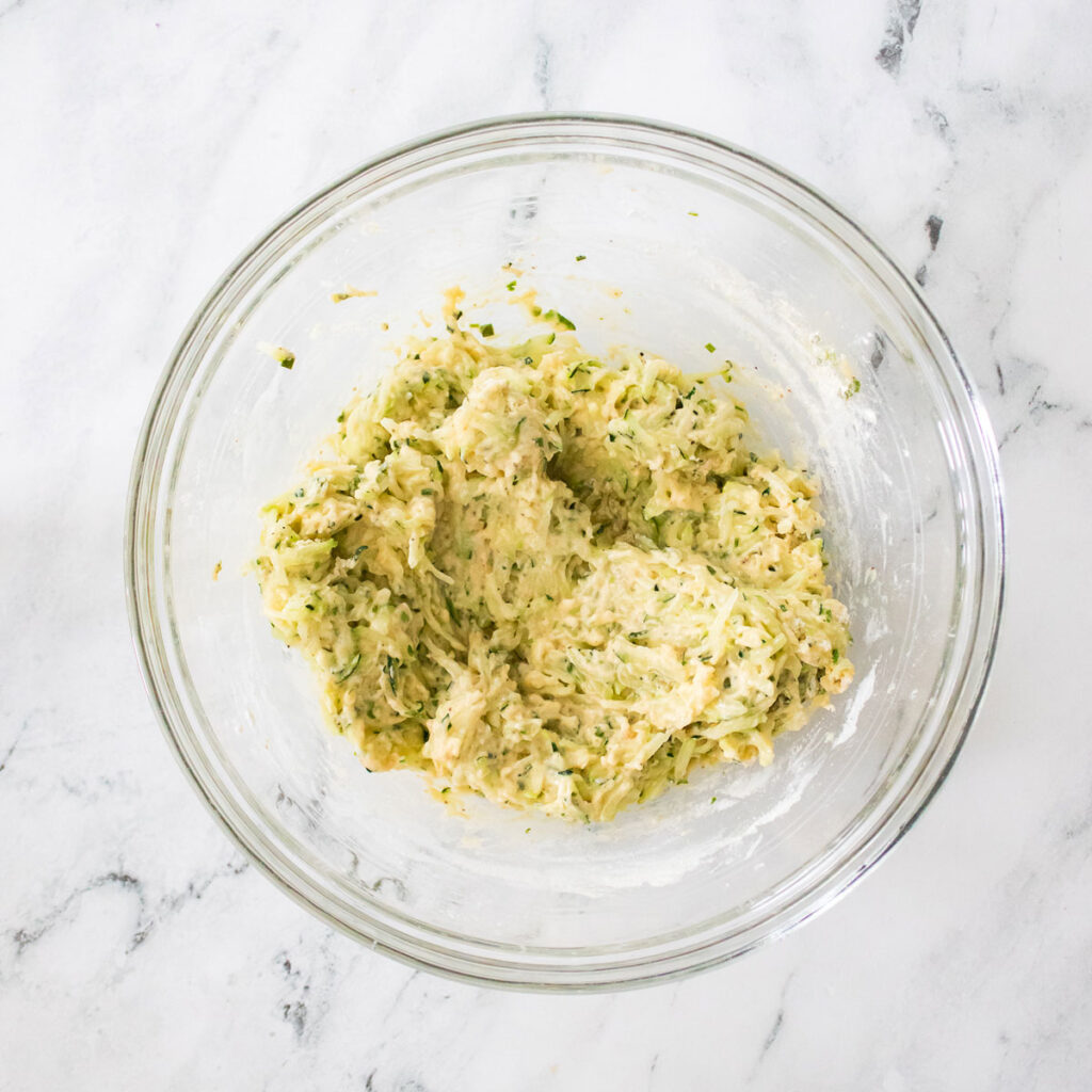 batter for zucchini fritters in glass bowl