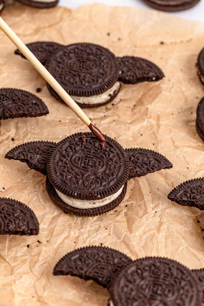 dabbing chocolate on oreo to make oreo bats