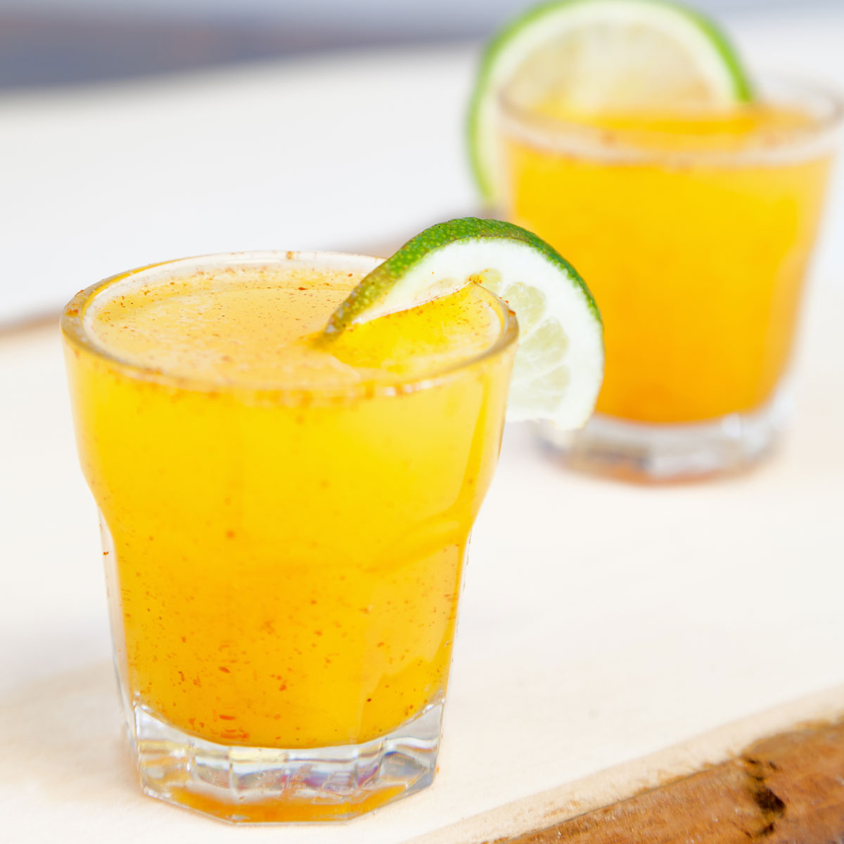 two glasses of cayenne lemonade garnished with lime slices