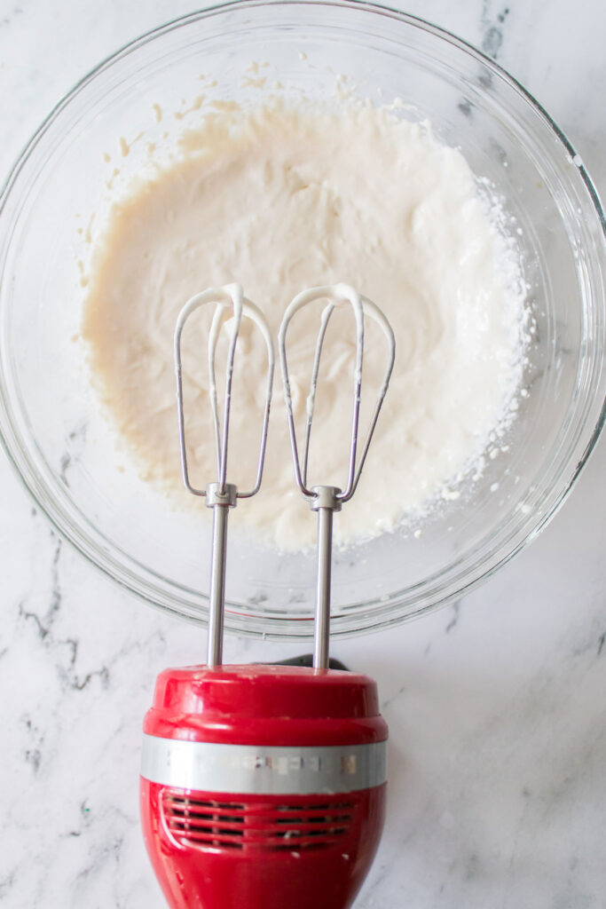 mixer over glass bowl of Little Debbie Christmas Tree dip