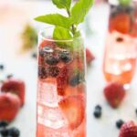 flute of berry sangria with cocktail name overlay