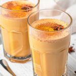 turmeric coffee latte in two glasses with recipe name overlay