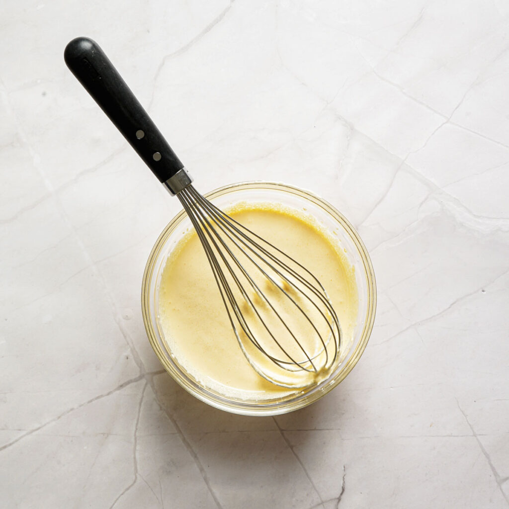 whisking tiramisu filling in glass bowl
