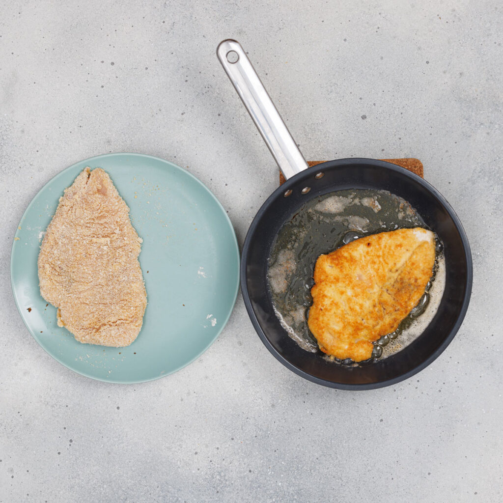 frying chicken parmesan in pan