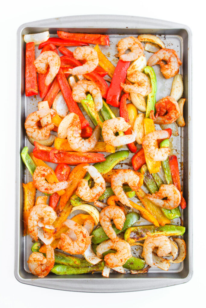 sheet pan with shrimp and sliced peppers and onions