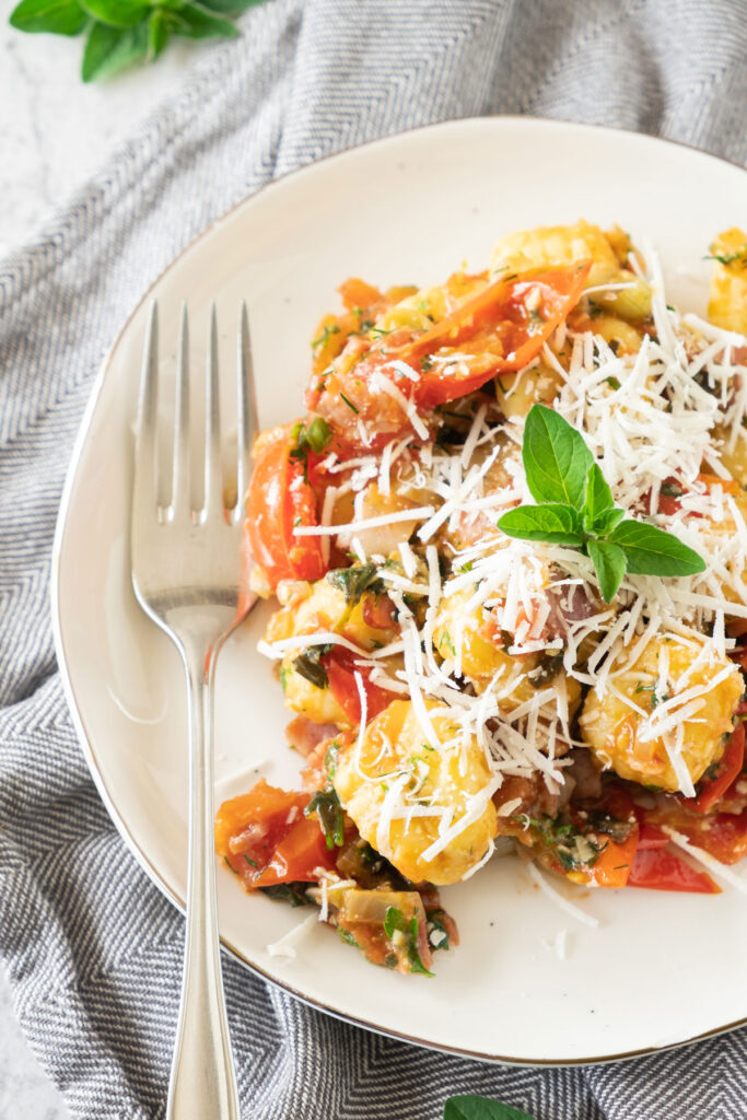 bacon gnocchi on white plate with fork