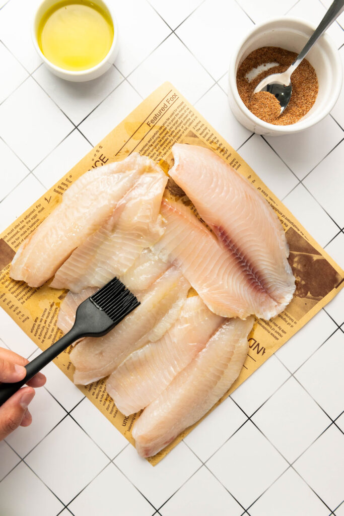 brushing raw fish fillets with oil
