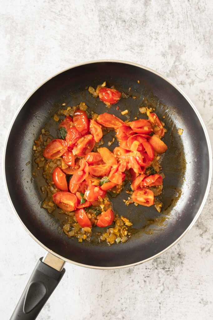 cooking garlic and tomatoes in pan