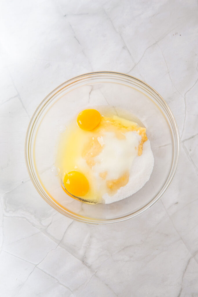 egg, mashed banana, and sugar in glass bowl