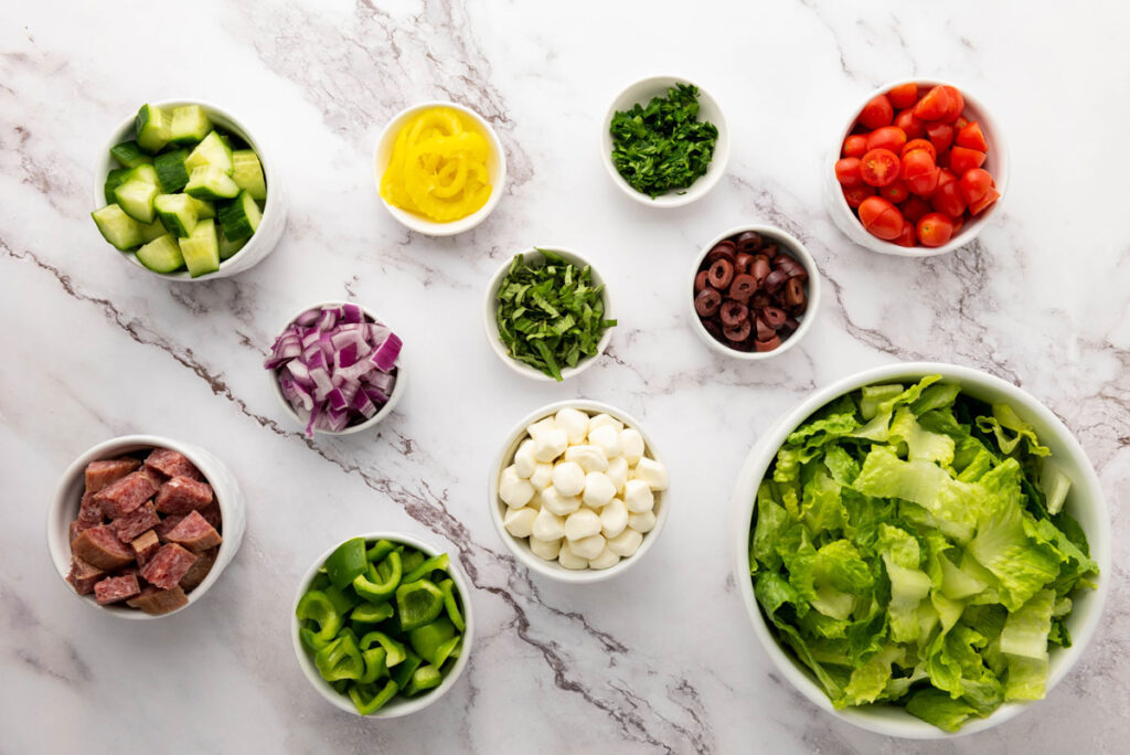 salad ingredients in bowls on marble counter
