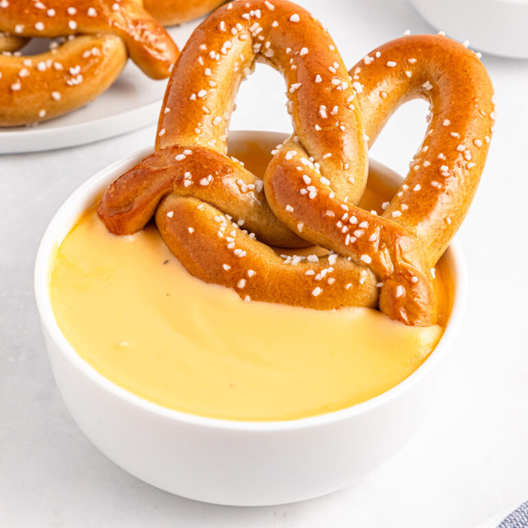 large pretzel in bowl of easy cheese sauce