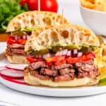 two halves of carne asada tortas on plate