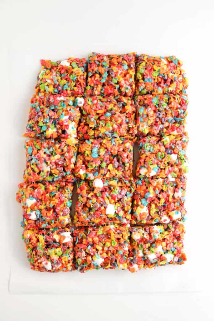 fruity pebble treats cut into squares on counter