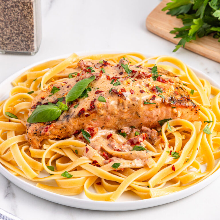 marry me salmon over linguine on white plate