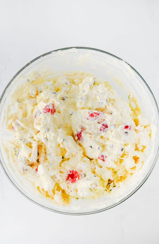 mixing banana split fluff salad in bowl