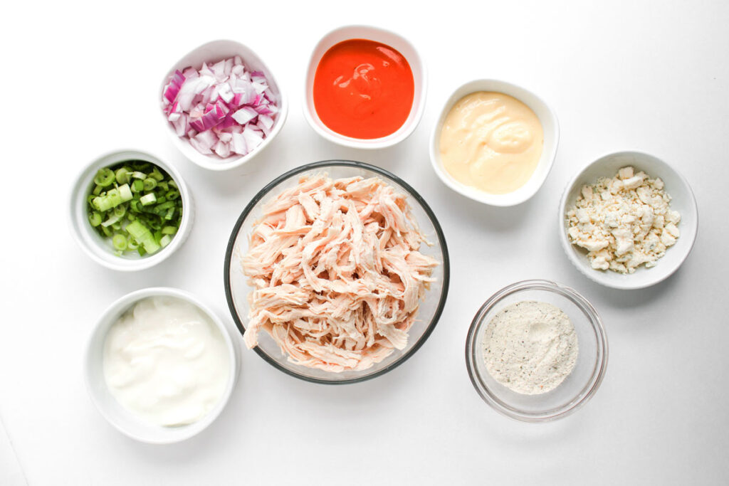 buffalo chicken salad ingredients in bowls on countertop