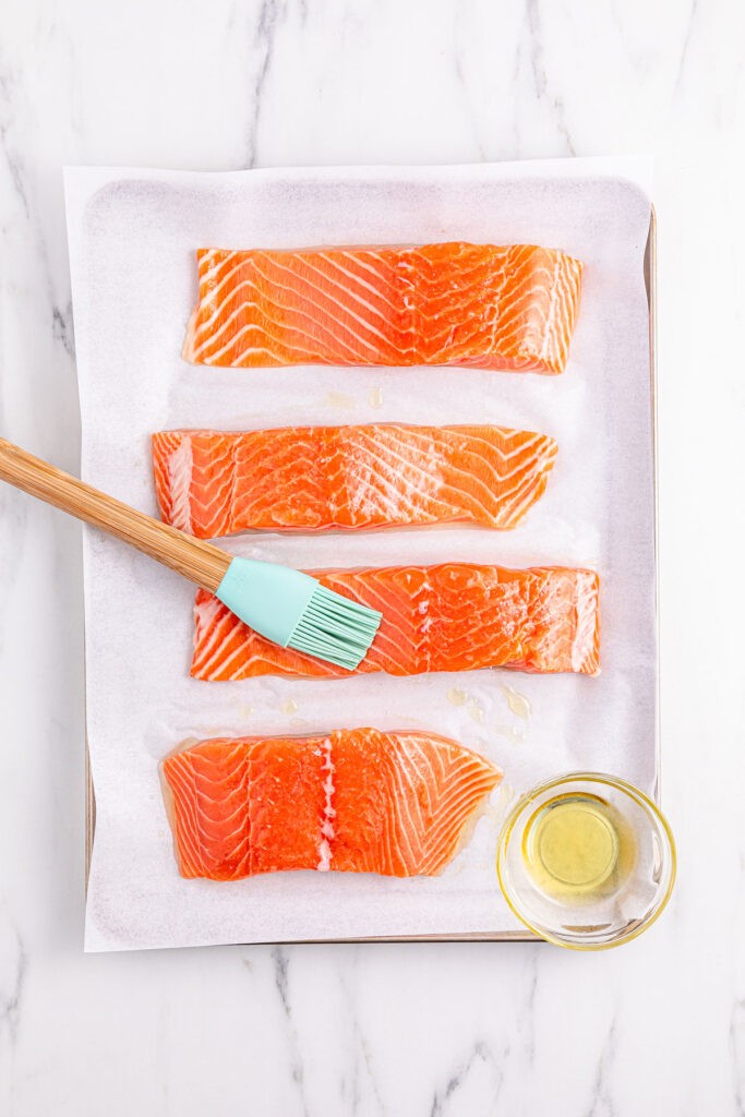brushing olive oil on salmon filets