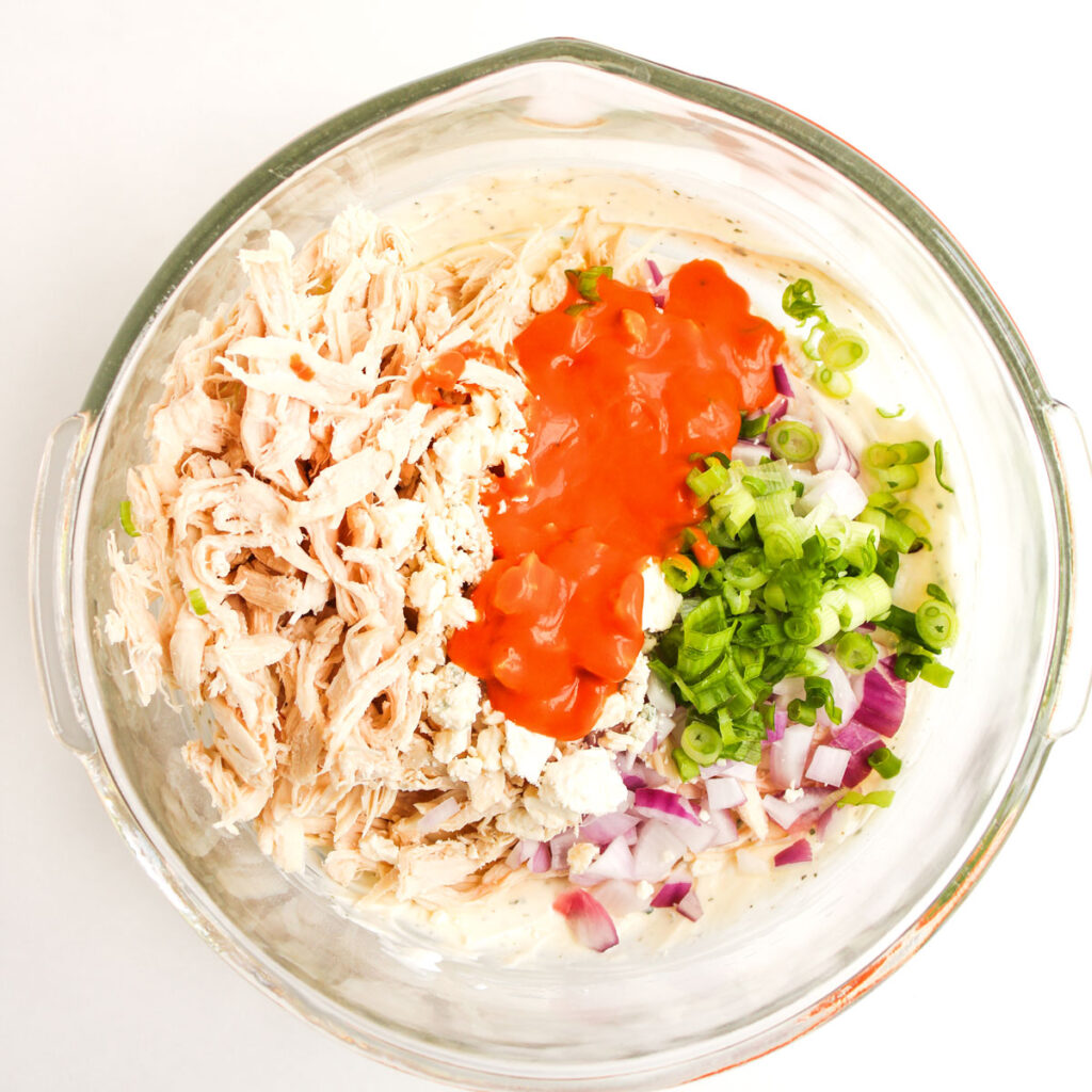 buffalo chicken salad ingredients in glass bowl