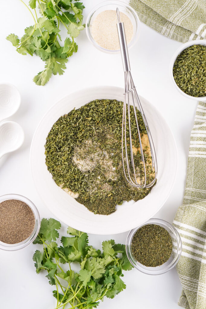 whisking homemade ranch seasoning in white bowl