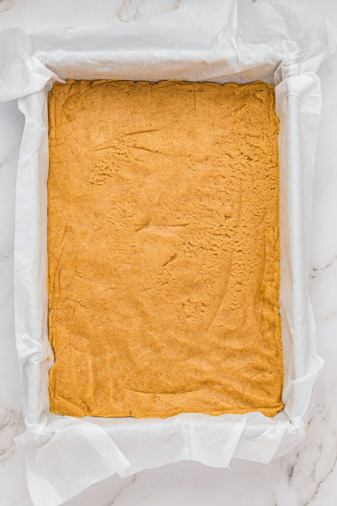 cookie dough pressed into baking dish