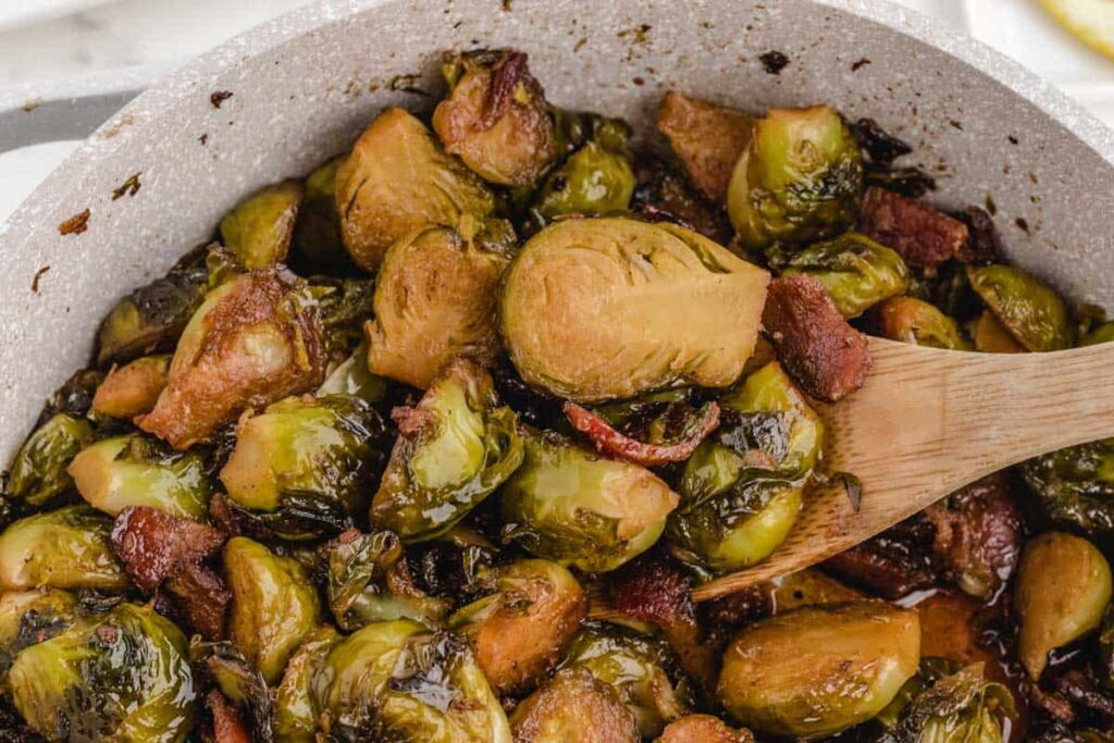brown sugar brussel sprouts in bowl with wooden spoon