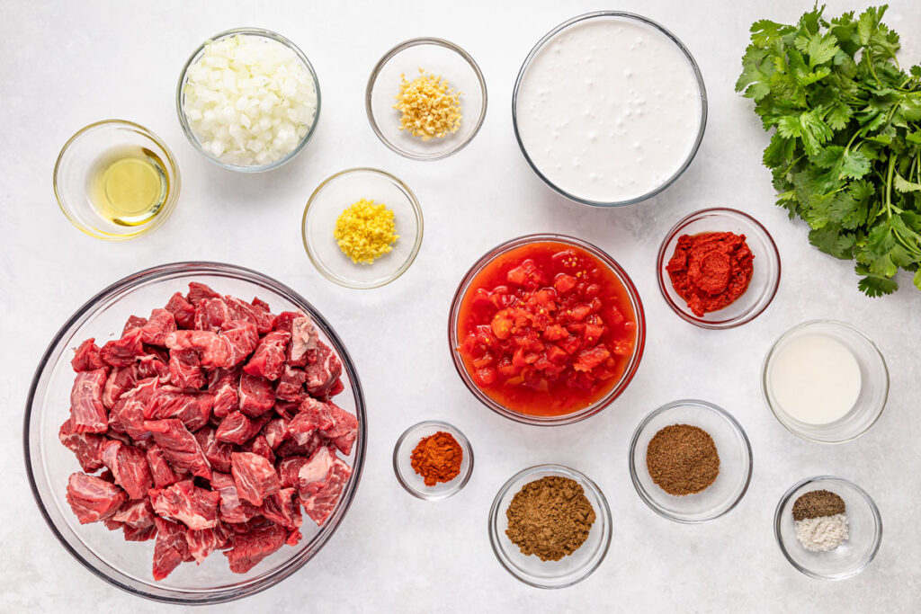 slow cooker beef curry ingredients in bowls on countertop