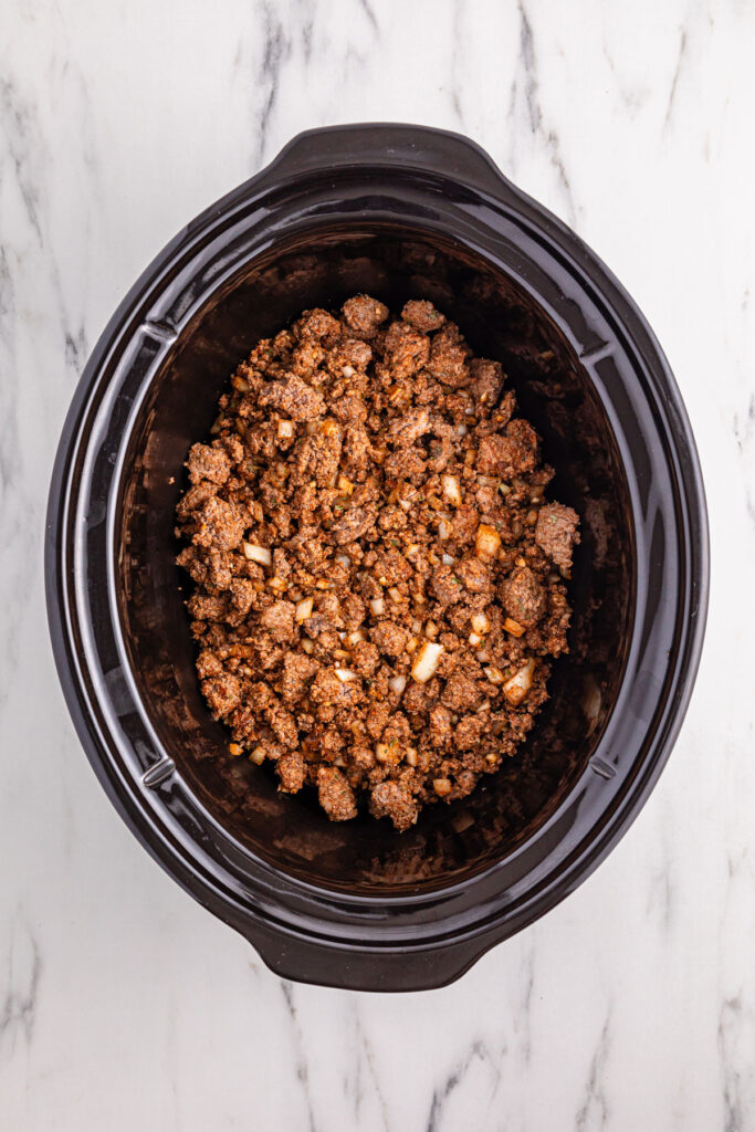 browned ground beef and onions in slow cooker for chili