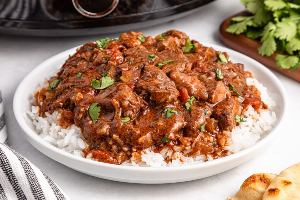 slow cooker beef curry over rice on plate