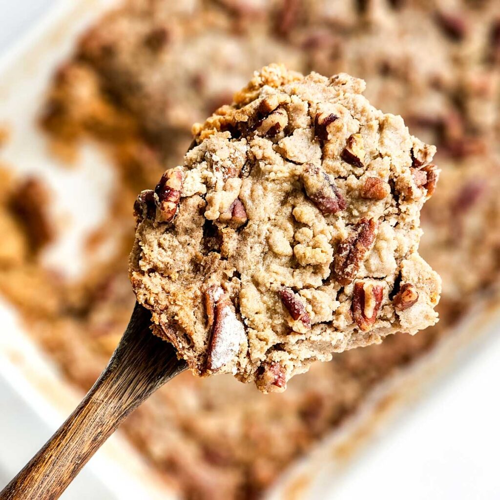 sweet potato dump cake in spoon over baking dish