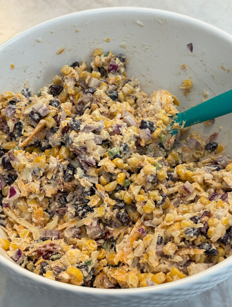 spatula mixing cowboy corn dip in large white bowl