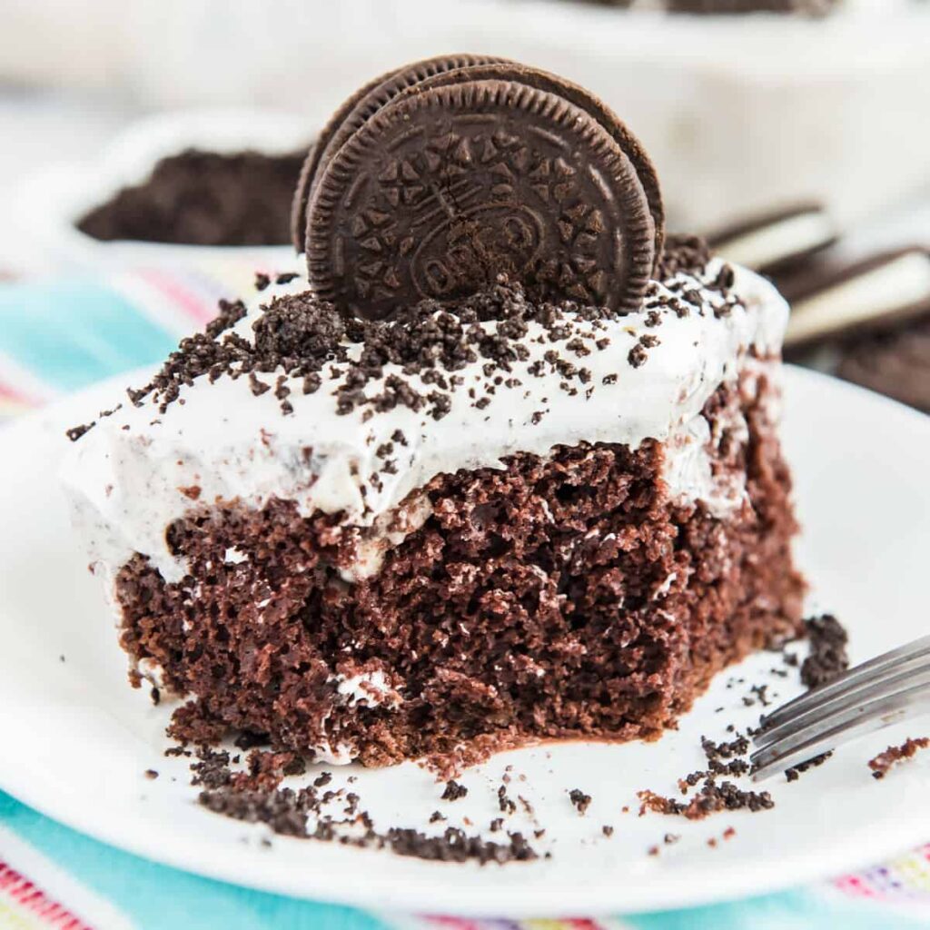 serving of oreo poke cake on white plate
