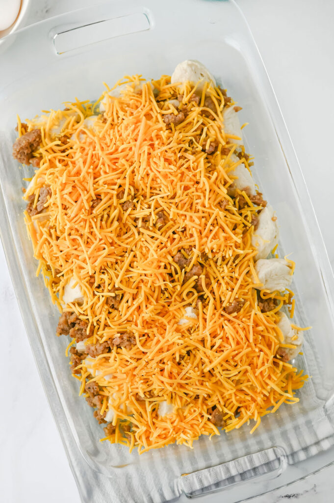 biscuits, sausage, and shredded cheese in casserole dish