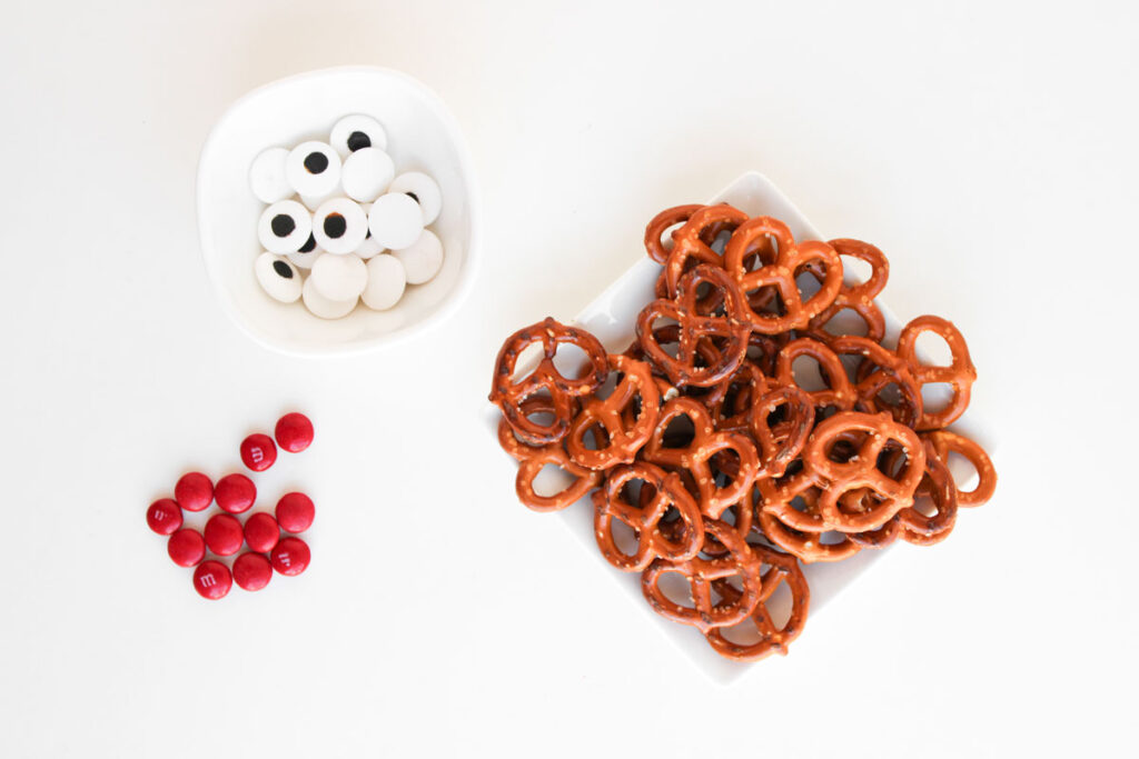 pretzels, eyeball candies and red M&Ms on white counter