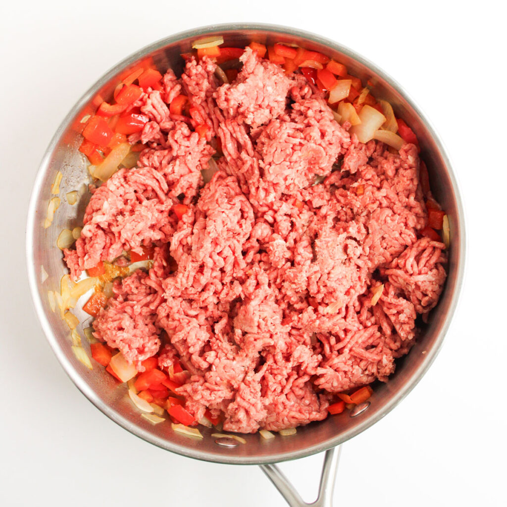 browning meat with diced vegetables to make cowboy casserole