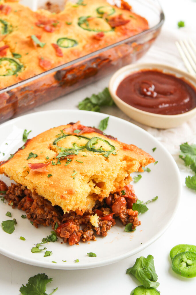 serving of cowboy casserole on plate in front of casserole dish